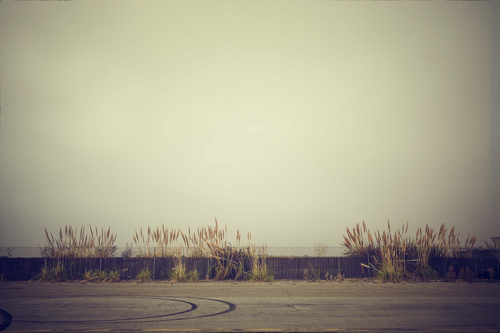 GRID MARKS by Frank Kayser — tyre traces, fence and dry grass at Naval Air Station Alameda